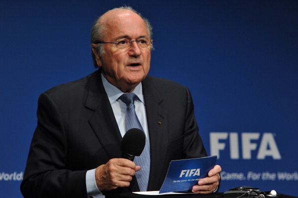 Sepp Blatter_with_microphone_in_front_of_FIFA_logo