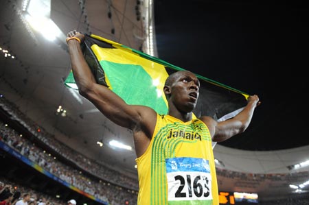 Usain Bolt_with_flag_in_Beijing_26-03-12
