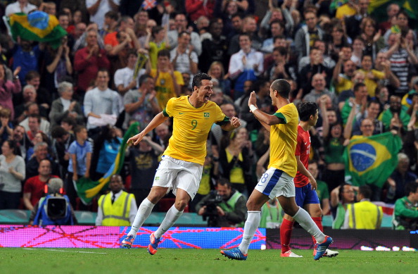 Leandro Damiao_L_celebrates_scoring_Brazils_defender_Romulo_R