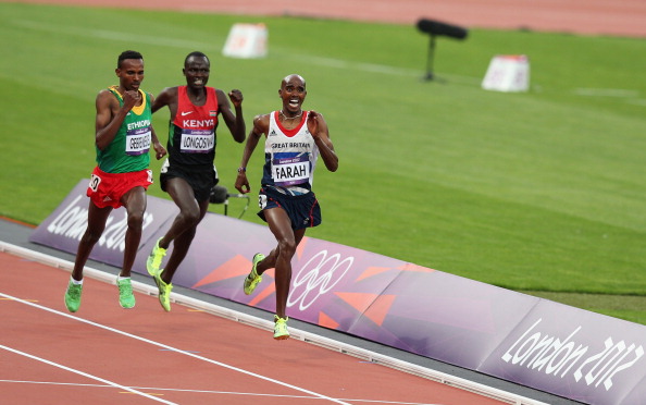 Mohamed Farah_of_Great_Britain_crosses_the_finish_line_to_win_gold_ahead_of_Dejen_Gebremeskel_of_Ethiopia_and_Thomas_Pkemei_Longosiwa_of_Kenya_in_the_Mens_5000m_Final