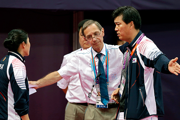 Referee Torsten_Berg_second_from_right_talks_to_South_Korean_coach_Sung_Han-kook_right_after_Berg_issued_a_black_card_to_the_players_in_the_womens_doubles_match_between_South_Korea_and_Indonesia