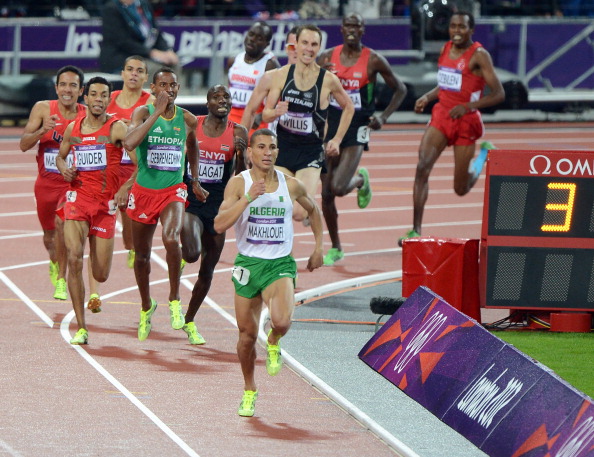 Taoufik Makhloufi_leads_the_field_as_it_comes_around_the_final_bend_of_the_mens_1500m_race