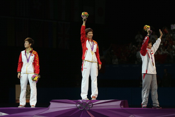 Xiaoxia Li_of_China_stands_on_the_podium_after_winning_the_Gold_medal_Ning_Ding_of_China_L_the_Silver_and_Tianwei_Feng_of_Singapore_R_the_Bronze_following_the_Womens_Singles_Table_Tennis_Gold