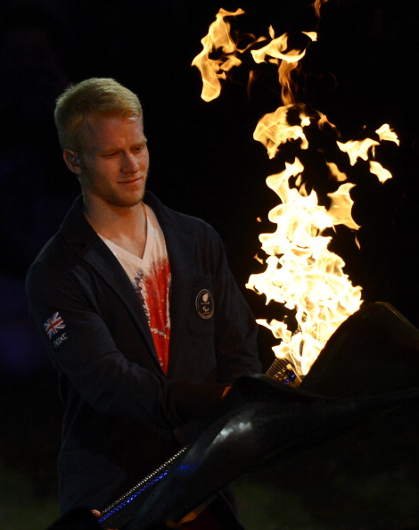 Britains Paralympic_sprinter_Jonnie_Peacock_colllects_the_Paralympic_Flame_to_extinguish_it_as_the_cauldron_unwinds_for_the_final_time_during_the_closing_ceremony