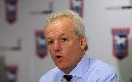 Simon Clegg in front of Ipswich Town logo