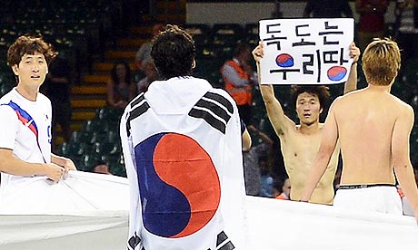 Park Jong-woo with political sign at London 2012 surrounded by team-mates