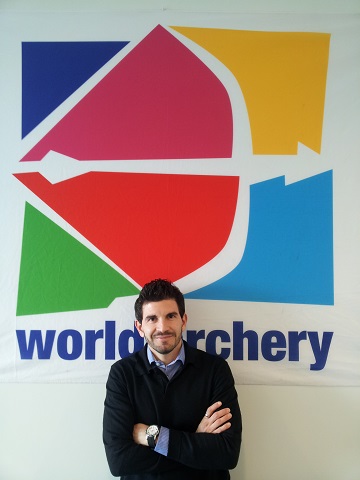 Marcos Lorenzo in front of World Archery sign