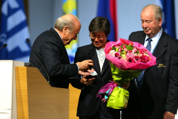 Sepp Blatter presents Moya Dodd with flowers and her FIFA pin