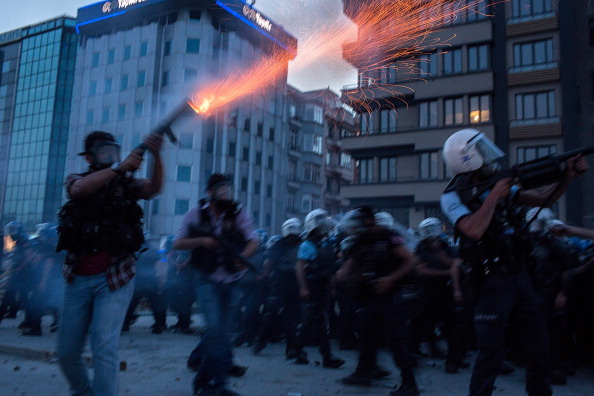 Riot police fire tear gas to disperse the crowd during a demonstration near Taksim Square
