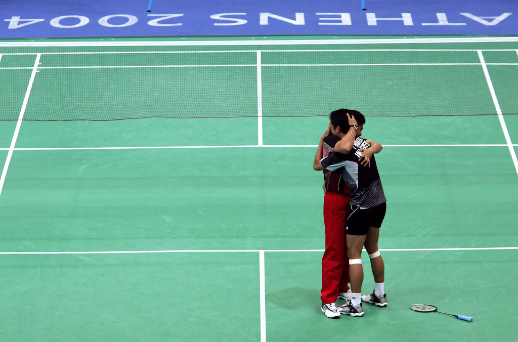 Taufik Hidayat of Indonesia celebrates with his coach Mulyo Handoyo red pants after defeating Seung Mo Shon of Korea in the mens singles badminton gold medal match