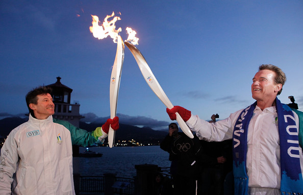 Arnold Schwarzenegger hands the Olympic flame Sebastian Coe ahead of Vancouver 2010