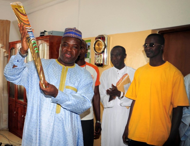 Gambia's Minister of Youth and Sports Sheriff Gomez holds the Queen's Baton when it visited Banjul in 2010 before the New Delhi Commonwealth Games