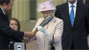 Queen Elizabeth II inspects the Glasgow 2014 baton