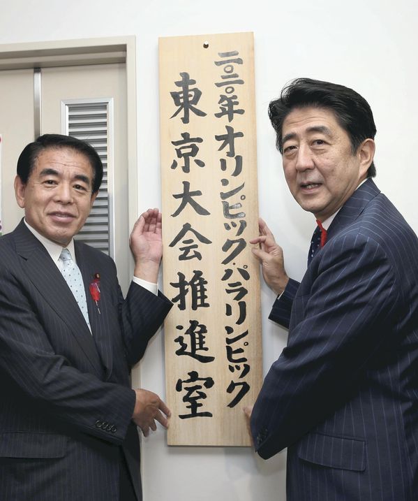 Japan's Prime Minister Shinzo Abe (right) and Olympics Minister Hakubun Shimomura put up a sign at the new Tokyo 2020 headquarters in the Cabinet Office