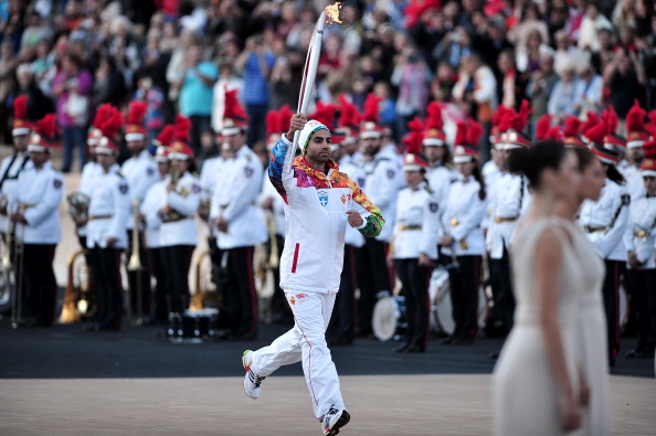 Greek figure skater Panagiotis Markouizos carried the Olympic Torch into the Panathenaic Stadium in Athens before it was handed over to Sochi 2014