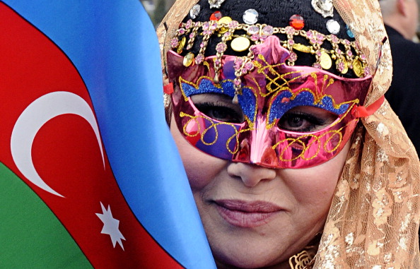 A masked woman holds an Azerbaijani flag as she takes part in the celebration of Navruz, the Central Asia's spring welcome festival, in Baku, the capital of Azerbaijan, on March 19, 2013. © Getty Images