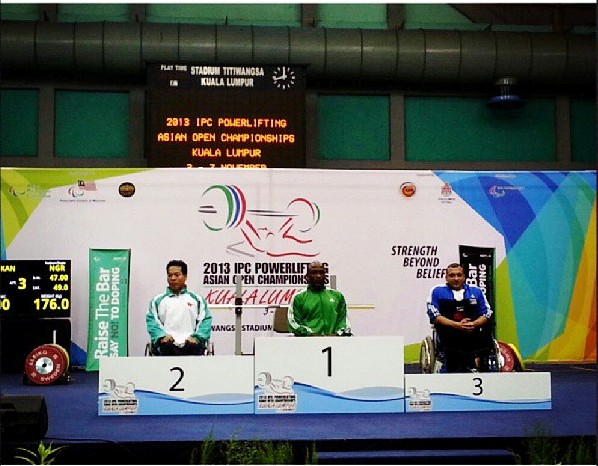 Paralympic champion Yakubu Adesokan (centre) recieves  his gold medal at the IPC Powerlifting Asian Open Championships