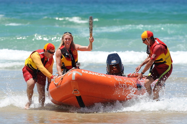 Sally Pearson holds aloft the baton as it arrives on the Gold Coast