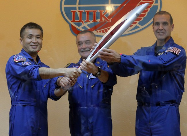 The three figures on board the rocket proudly hold the Torch ahead of their departure to the International Space Station