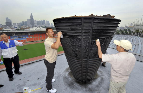 Bungo Suzuki and Athens 2004 champion Koji Murofushi polish the Cauldron, with the former having done so every autumn since the Tokyo 1964 Games ©Bloomberg/Getty Images