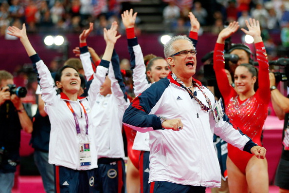 John Geddert, coach to the US women's gymnasts, enjoys the atmosphere with athletes at London 2012 during the last rotation in the team final. The number of nations winning medals in gymnastics events at London 2012 rose to 18 ©Getty Images