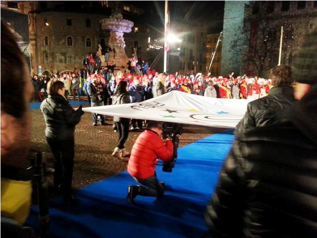 The FISU flag makes its way through the crowds in the Piazza Duomo