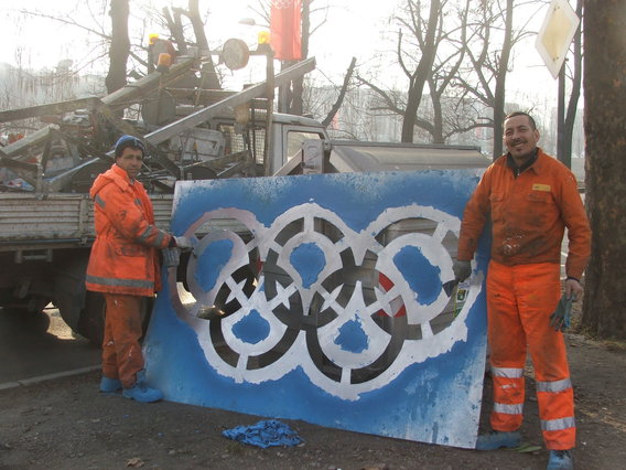 Workmen in Turin use a template of the Rings to make the Olympic lanes for official traffic ©Philip Barker