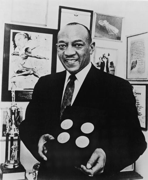 Jesse Owens smiles as he poses with the four gold medals he won at the 1936 Berlin Olympics ©Hulton Archive/Getty Images