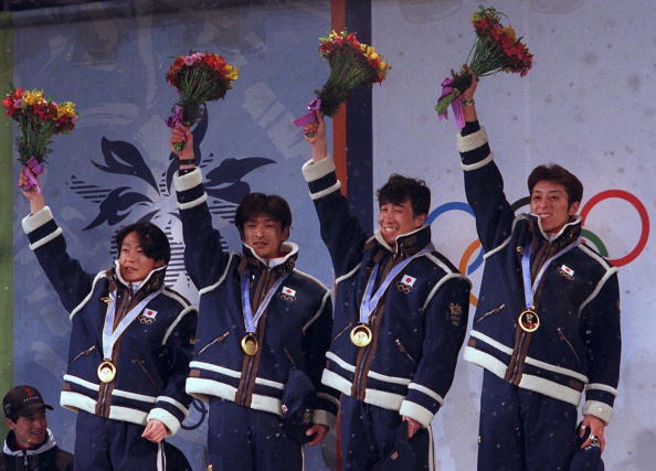 Masahiko Harada (second right) celebrates victory in the 1998 Olympic team ski jump competition ©Getty Images