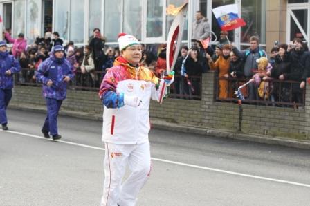 Kim Jin-sum carries the Torch on the streets of Sochi close to the Olympic Park today ©Pyeongchang 2018