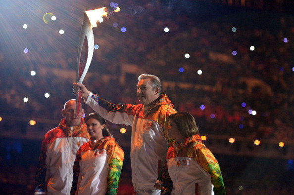 Vladislav Tretiak and Irina Rodnina carry the Flame out of the Stadium to light the Olympic Cauldron ©AFP/Getty Images