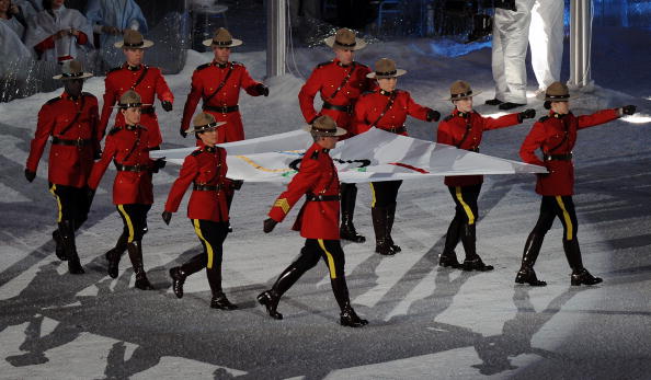 The Royal Canadian Mounted Police troop the Olympic flag from the arena during the Vancouver 2010 Closing Ceremony ©AFP/Getty Images