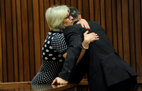 Oscar Pistorius is hugged by his aunt Lois during another day examining how evidence was gathered inside his home after the shooting ©AFP/Getty Images