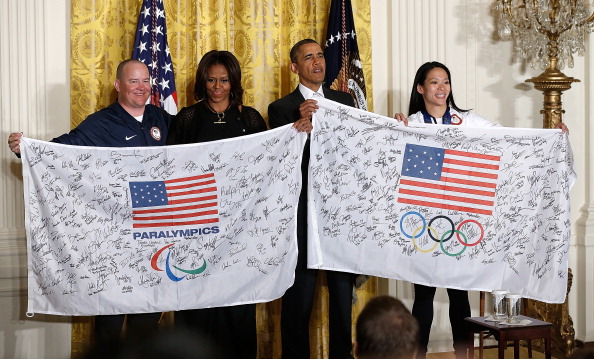Barrack and Michelle Obama receiving autographes flags from the US Olympic and Paralympic teams ©Getty Images