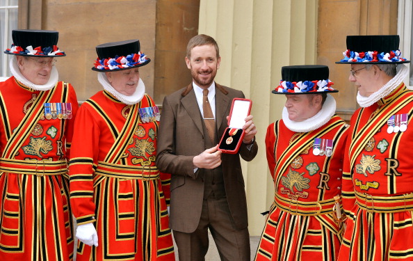Sir Bradley Wiggins, pictured with Beefeaters after receiving his knighthood last year at Buckingham Palace, has indicated he will be competing at the Glasgow Commonwealth Games this summer ©Getty Images