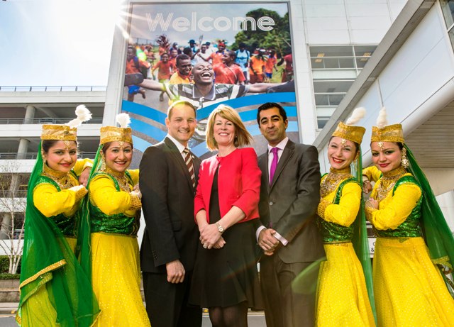 Glasgow 2014 chief executive, David Grevemberg, managing director of Glasgow Airport Amanda McMillan and Scottish Minister Humza Yousaf are joined by the Desi Bravehearts at Glasgow Airport ©Glasgow 2014