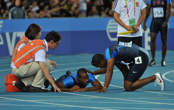 A floored Darvis Patton is attended to by US teammate Walter Dix and officials after falling during the final 4x100m changeover at the 2011 IAAF World Championships in Daegu ©Getty Images