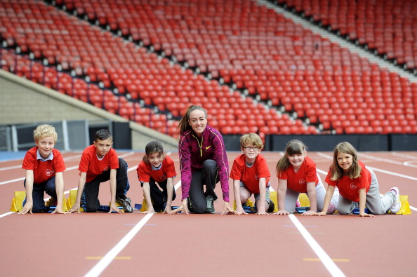 Eilish McColgan, and pupils from Mount Florida Primary School, get a first feel of the new track at Hampden Park this week ahead of the IAAF Diamond League meeting and Glasgow 2014 Games ©Getty Images