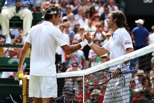 Seven-time champion Roger Federer (left) shakes hands with Italian Paolo Lorenzi after winning their first round match at Wimbledon ©Getty Images 