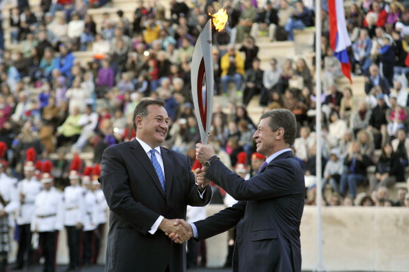 Spyros Capralos (left) hands over the Olympic Torch for Sochi 2014 at Panathenaic Stadium in Athens to Russian Deputy Prime Minister Dmitry Kozak ©Getty Images