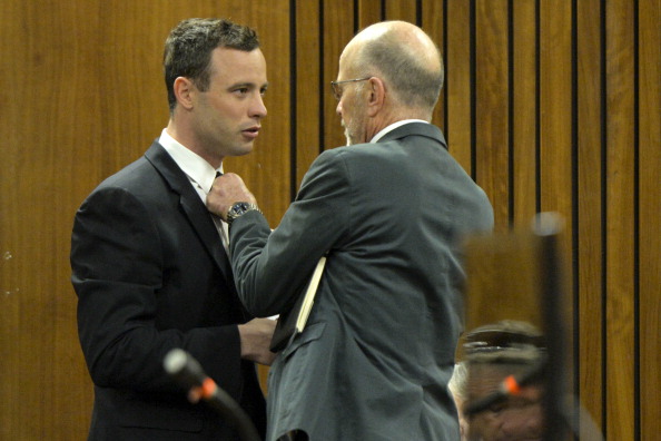 Arnold, Oscar Pistorius' uncle, helps the Paralympic athlete with his tie during today's proceedings in court ©Getty Images