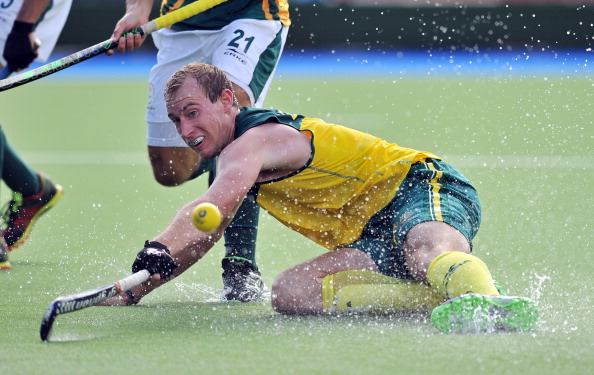 Australia's Aran Zalewski scrambling for the ball in a 6-0 thrashing of South Africa in their men's hockey clash ©AFP/Getty Images