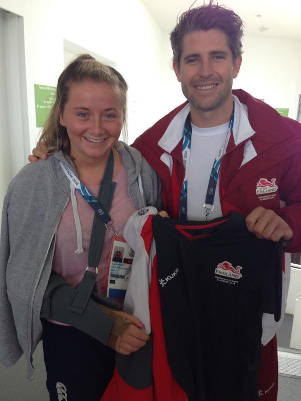Simon Mantell presents Anna Walmsley with a shirt after knocking her over in England's hockey fixture with New Zealand ©Twitter