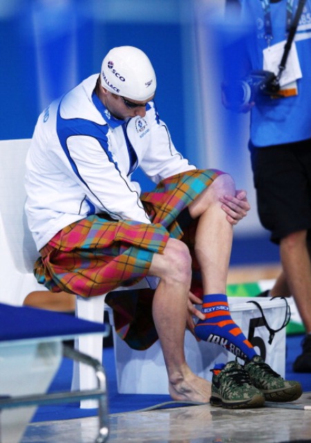 Daniel Wallace gets his kilt off before powering his way to silver and Scotland's last swimming medal at Glasgow 2014 ©Getty Images 