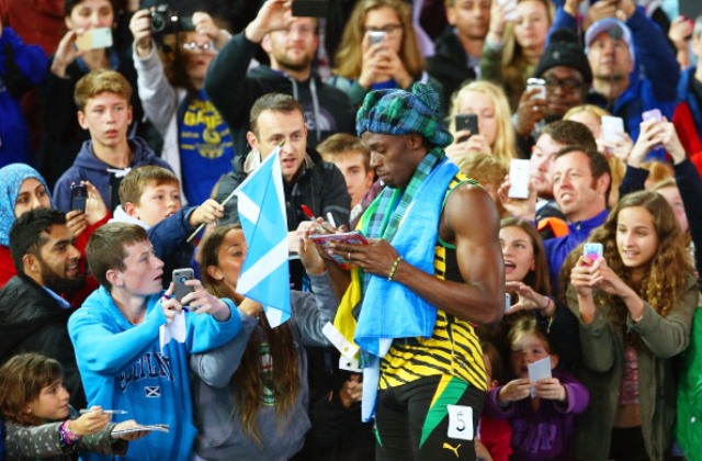 Fans scramble for an autograph from Usain Bolt at Hampden Park, one of the biggest attractions at Glasgow 2014 ©Getty Images