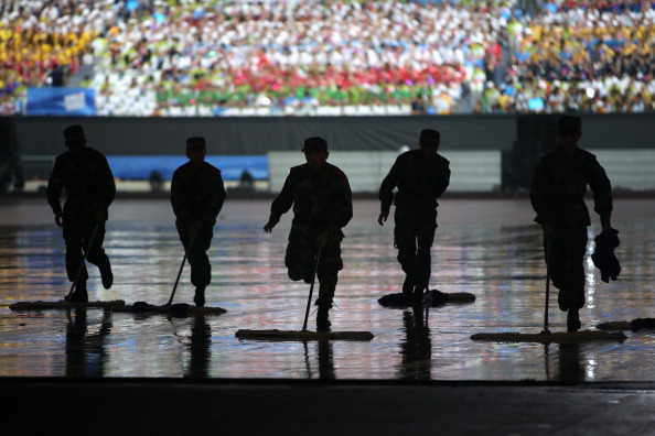 Soldiers helped remove water from the centre of the stadium as rain lashed Nanjing ©Getty Images