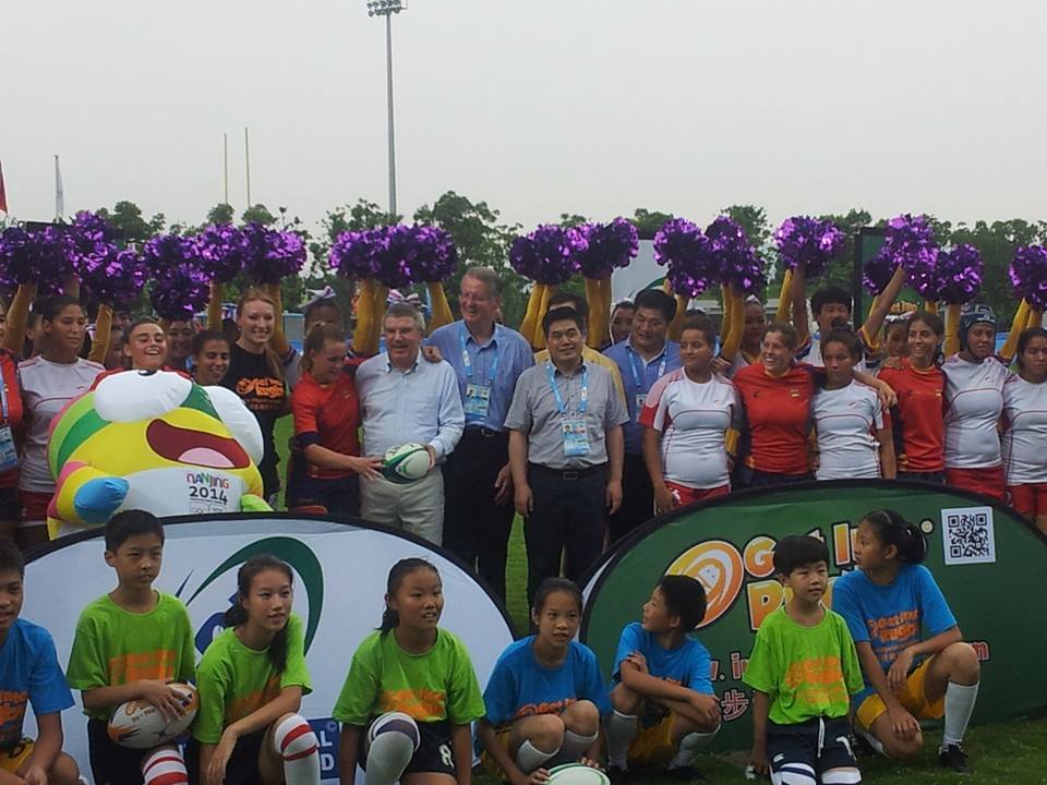 Thomas Bach alongisde IRB President Bernard Lapasset and a multitude of fans, dancers and rugby sevens players ©ITG