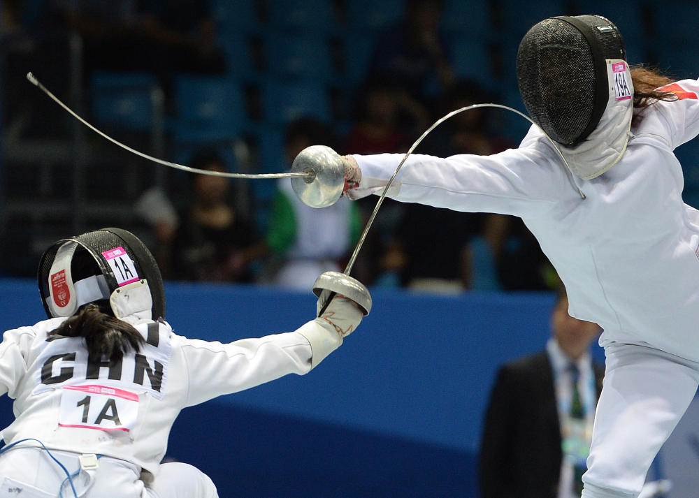 Zhong Xiuting (left) of China went up against Valeriia Uvarova of Kyrgyzstan in the fencing round of the mixed international team relay event of the modern pentathlon competition ©Nanjing 2014