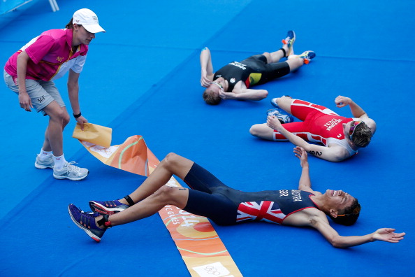 Ben Dijkstra of Great Britain, Daniel Hoy of New Zealand and Emil Deleuran Hansen of Denmark, who won gold, silver and bronze respectively, collapsed at the finish line after a gruelling men's triathlon ©Getty Images