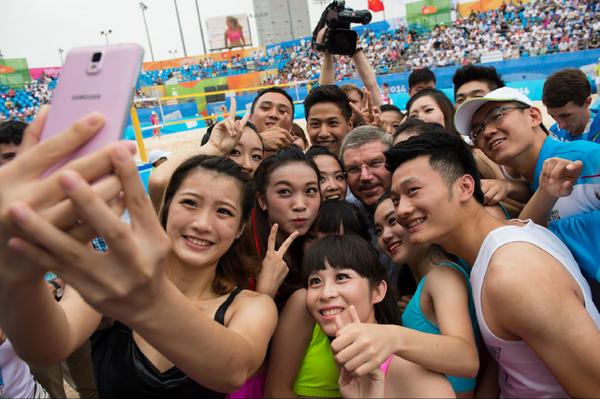 Thomas Bach with dancers, volunteers and others at the beach volleyball ©Twitter